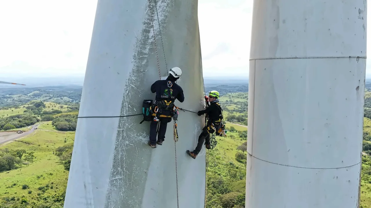 Técnicos de CORE-TEC trabajando con cuerdas en un aerogenerador